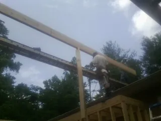 Carpenter setting a ridge beam over a new addition frame — Ice Dam Removal by Roofing Brothers in Perkiomenville