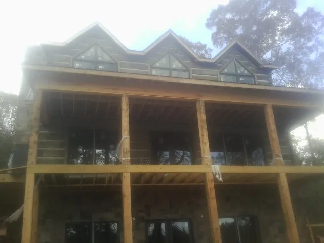 Dormers and porch framing on a large log home under construction — Roof Coating work by our crew in Perkiomenville