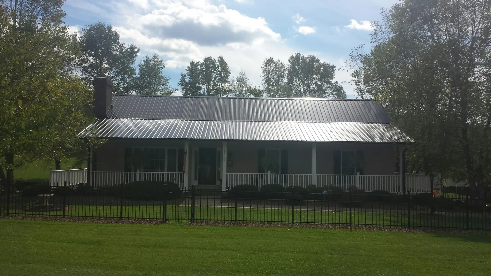 Gray metal roof on a brick ranch with a full width front porch — Gutter Guard Installation work by our crew in Perkiomenville